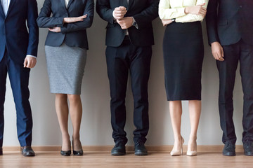 Legs of diverse work team pose for corporate photoshoot or make picture, job applicants in suits...