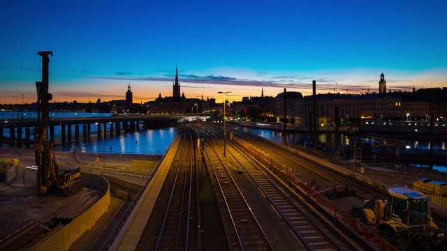 Midnight sunset time lapse of Gamla Stan island taken over the subway train tracks in Stockholm, Sweden