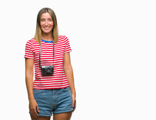 Obraz premium Young beautiful woman taking pictures using vintage photo camera over isolated background looking away to side with smile on face, natural expression. Laughing confident.