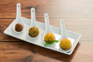 Fried italian meat balls in a white plate on wooden background, Apulia, Salento, Italy