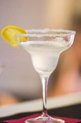 margarita alcohol cocktail in a glass on a background of bright lights i with lemon