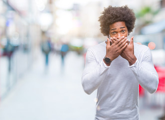 Afro american man over isolated background shocked covering mouth with hands for mistake. Secret concept.