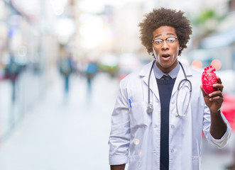 Afro american cardiologist doctor man over isolated background scared in shock with a surprise face, afraid and excited with fear expression