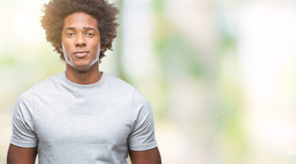 Afro american man over isolated background with serious expression on face. Simple and natural looking at the camera.