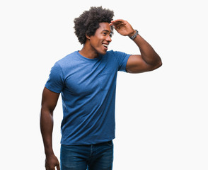 Afro american man over isolated background very happy and smiling looking far away with hand over...