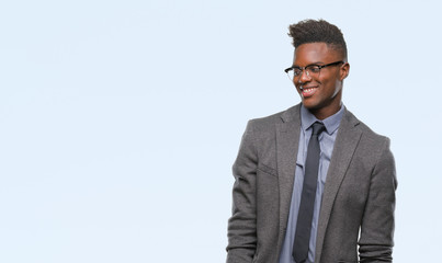 Young african american business man over isolated background looking away to side with smile on face, natural expression. Laughing confident.
