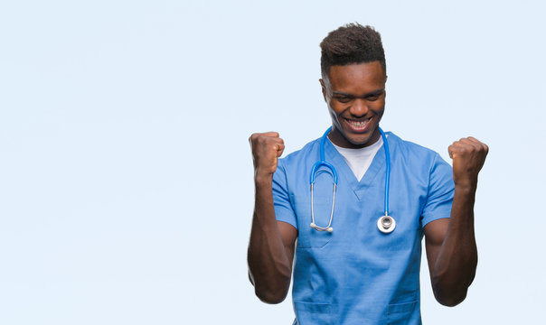 Young african american doctor man over isolated background wearing surgeon uniform celebrating surprised and amazed for success with arms raised and open eyes. Winner concept.