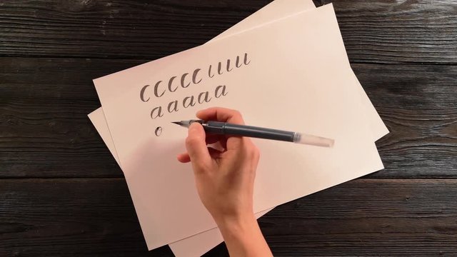 hand with penbrush does lettering exercise