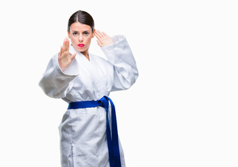 Young beautiful woman wearing karate kimono uniform over isolated background happy face smiling with crossed arms looking at the camera. Positive person.