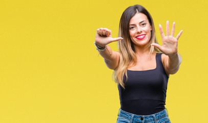 Young beautiful woman over isolated background showing and pointing up with fingers number six...