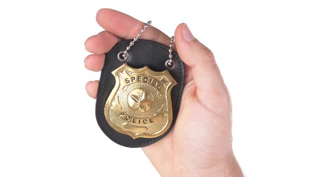 Holding a police officer golden badge in the hand. Cops indentification