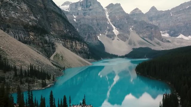 drone flying over the rocks at Moraine Lake, Banff, Alberta, Canada slow pan up to mountains