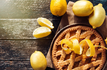 Delicious lemon pie with cooking ingredients on the wooden table 
