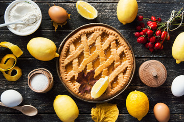 Fototapeta na wymiar Delicious lemon pie with cooking ingredients on the wooden table 