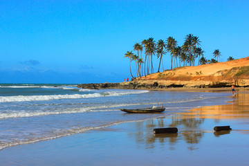 Lagoinha Beach, Ceará: palm trees, rocks, red sand hill, boat, logs, people, waves, reflection