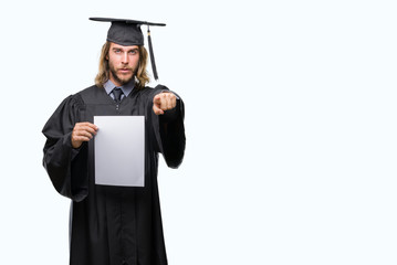 Young handsome graduate man with long hair holding blank paper over isolated background pointing with finger to the camera and to you, hand sign, positive and confident gesture from the front