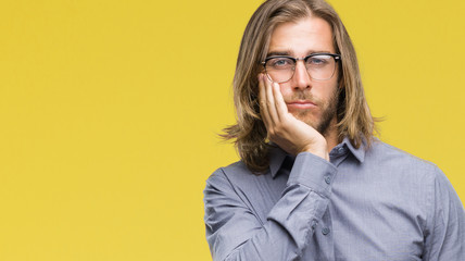 Young handsome business man with long hair over isolated background thinking looking tired and bored with depression problems with crossed arms.