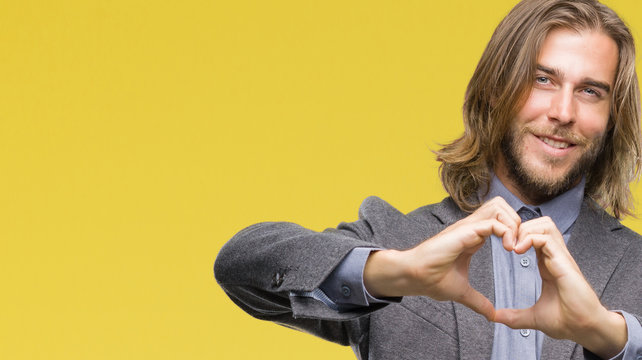 Young handsome business man with long hair over isolated background smiling in love showing heart symbol and shape with hands. Romantic concept.