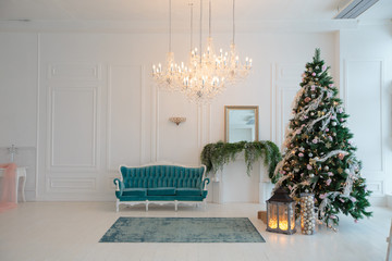 Green Christmas tree with a pink decor. Turquoise couch in the interior decorated for Christmas.