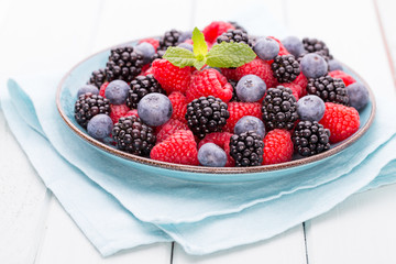 Fresh raspberries in a plate on a  vintage background.