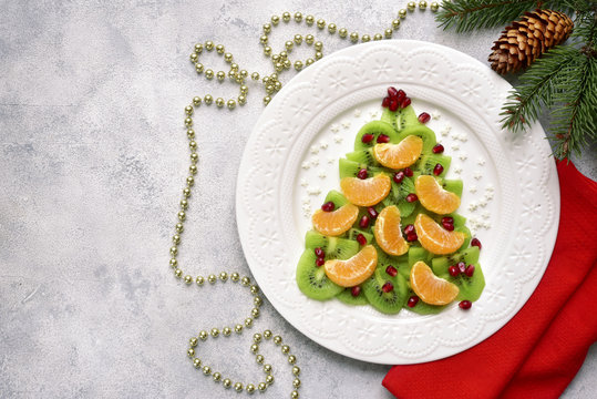 Edible christmas tree from kiwi and tangerine slices.Top view with copy space.