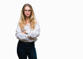 Fototapeta premium Young beautiful blonde business woman wearing glasses over isolated background skeptic and nervous, disapproving expression on face with crossed arms. Negative person.