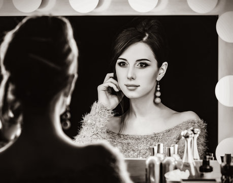 Portrait of a beautiful woman near a mirror. Image in black and white color style
