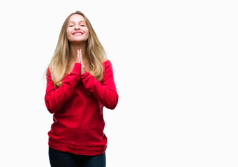 Obraz na płótnie Canvas Young beautiful blonde woman wearing red sweater over isolated background praying with hands together asking for forgiveness smiling confident.