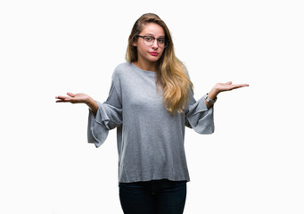 Young beautiful blonde woman wearing glasses over isolated background clueless and confused...