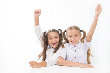 Schoolgirls happy keep hands up while sit at desk white background. Win school quiz. They know...