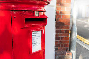 Close-up view of a old traditional vintage classic red letter box or postbox standing on sidewalk...