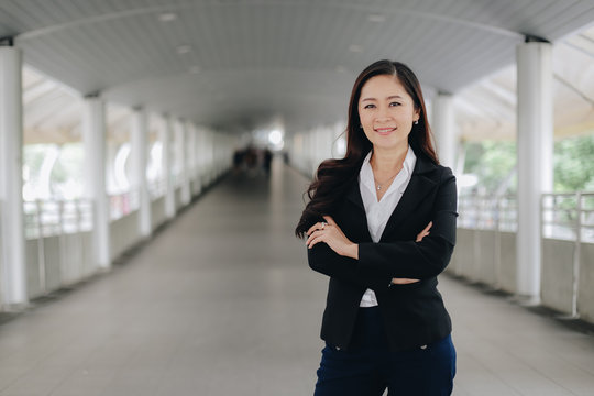 Successful asian senior businesswoman leader standing over modern pathway background