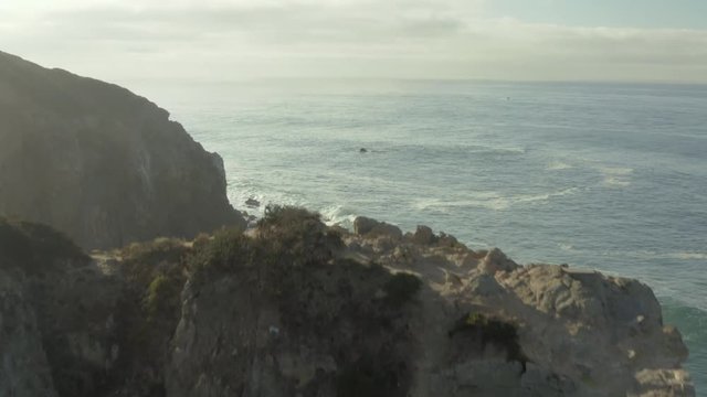 Aerial ascending shot and fly over of a cliff on the beach.