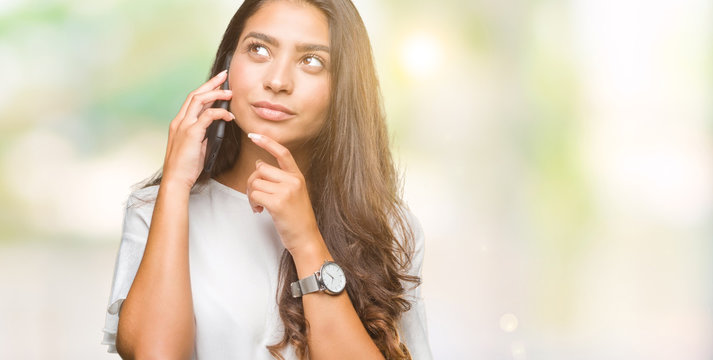 Young Beautiful Arab Woman Talking On The Phone Over Isolated Background Serious Face Thinking About Question, Very Confused Idea