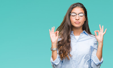 Young beautiful arab woman wearing glasses over isolated background relax and smiling with eyes closed doing meditation gesture with fingers. Yoga concept.