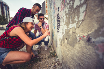 Three friends writing on old wall