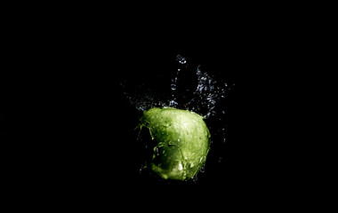Green apple with splashing water drops