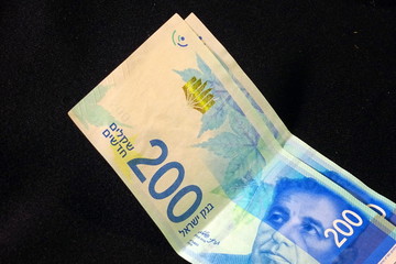 200 Israeli shekels bills on black