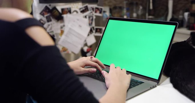 Woman using green screen laptop
