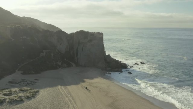 Aerial ascending shot and fly over of a cliff on the beach.