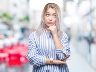 Fototapeta premium Young blonde woman over isolated background with hand on chin thinking about question, pensive expression. Smiling with thoughtful face. Doubt concept.