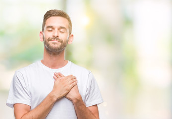 Young handsome man over isolated background smiling with hands on chest with closed eyes and grateful gesture on face. Health concept.