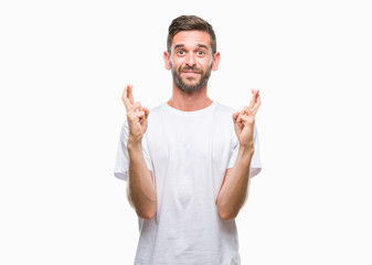 Fototapeta premium Young handsome man over isolated background smiling crossing fingers with hope and eyes closed. Luck and superstitious concept.