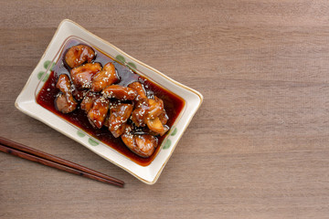 top view of chicken with teriyaki sauce in a ceramic plate on wooden table. delicious and popular japanese food menu.