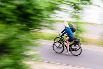 two bicycle riders on a cycle path in motion blur