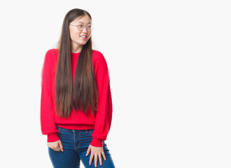 Young Chinese woman over isolated background wearing glasses looking away to side with smile on face, natural expression. Laughing confident.