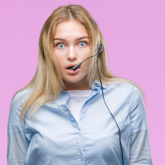 Young caucasian business woman wearing call center headset over isolated background afraid and shocked with surprise expression, fear and excited face.