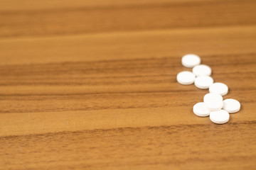 Fototapeta na wymiar pílula empilhados na mesa de madeira com pote