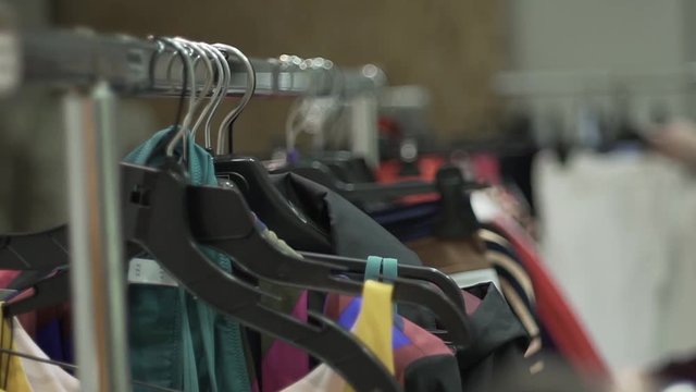 Clothing hanging on a clothing rack in a shop or home closet.