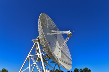 Array of satellite dishes or radio antennas against sky. Space observatory.